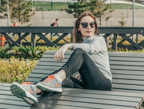 a woman sitting on top of a wooden bench